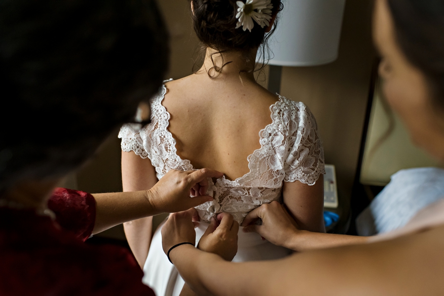 The bridesmaids help button the brides wedding dress before the ceremony in Philadelphia.